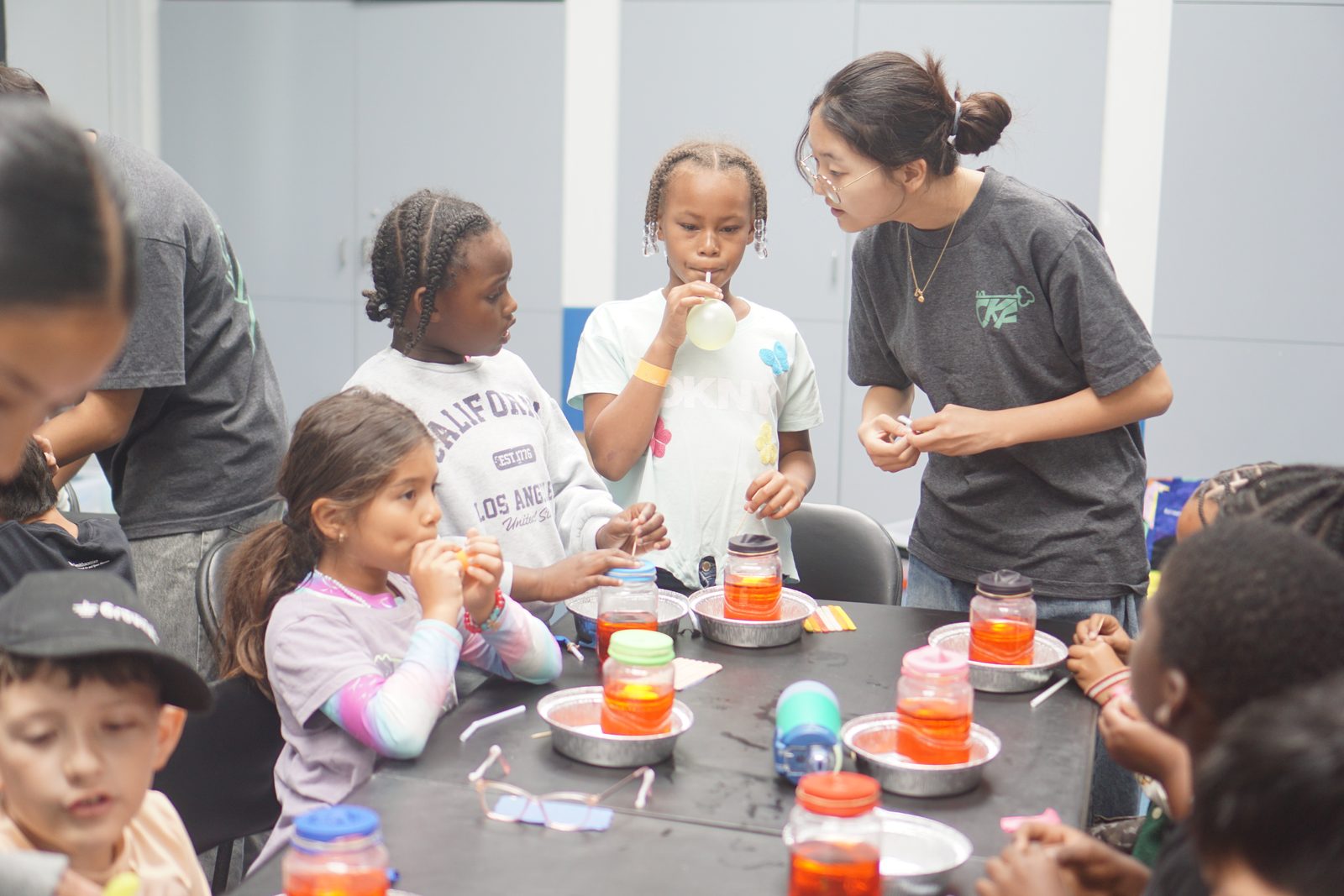 A CKF student running an experiment with children